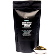Black tea packaging with text and a small bowl of tea leaves on a white background