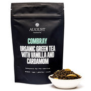 August Combray Organic Green Tea with Vanilla and Cardamom packaging and tea leaves in a bowl on a white background