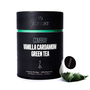 Black cylindrical container of Combray Vanilla Cardamom Green Tea with a tea bag on a white background