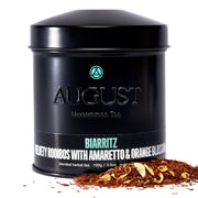 Black tea canister labeled 'August Tea' with tea leaves on a white background