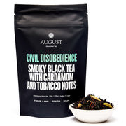 Tea package labeled 'Civil Disobedience' by August Uncommon Tea with a bowl of tea leaves.