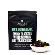 August Uncommon Tea package of 'Civil Disobedience' tea with a bowl of tea leaves on a white background