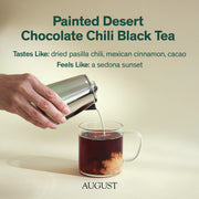 Tea being poured into a glass mug with 'Painted Desert Chocolate Chili Black Tea' text and 'August' branding.