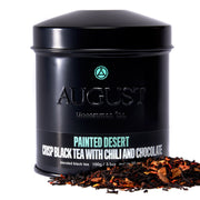 Black tea canister labeled 'August' with tea leaves on a white background