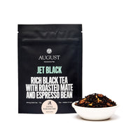 August Jet Black tea package with a bowl of tea leaves on a white background