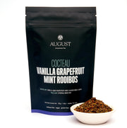 August tea package with 'Cocteau Vanilla Grapefruit Mint Rooibos' text, accompanied by a small bowl of tea leaves.