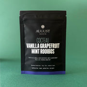 August Coctéau Vanilla Grapefruit Mint Rooibos tea package on a green background