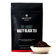 Black tea package with 'August' branding and a bowl of tea leaves on a white background