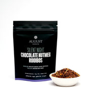 August tea package for 'Silent Night Chocolate Nutmeg Rooibos' with loose tea in a white bowl.
