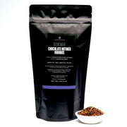 Black tea packaging with visible text and a small bowl of tea leaves on a white background