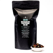 Black tea packaging with text and a small bowl of tea leaves on a white background