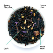 Tea blend with Assam Black Tea, Lemon Peel, Clove, and Dried Plum on a white background
