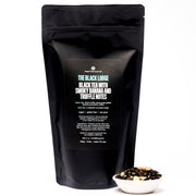 Black tea packaging with a bowl of tea leaves on a white background