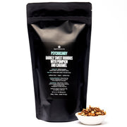 Black packaging of 'Psychocandy' with text and a small bowl of roasted seeds on a white background