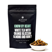 August tea package with white tea and ingredients in a bowl on a white background