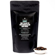 Black tea packaging with visible text and a small bowl of tea leaves on a white background