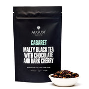 Black tea packaging with 'August' branding and tea description on a white background