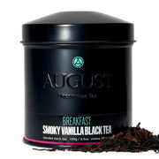 Black tea canister labeled 'August Uncommon Tea' with tea leaves on a white background