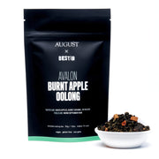 August x Bestia Avalon Burnt Apple Oolong tea package with a bowl of tea leaves on a white background