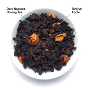 Dark roasted oolong tea with Turkish apple pieces in a white bowl.