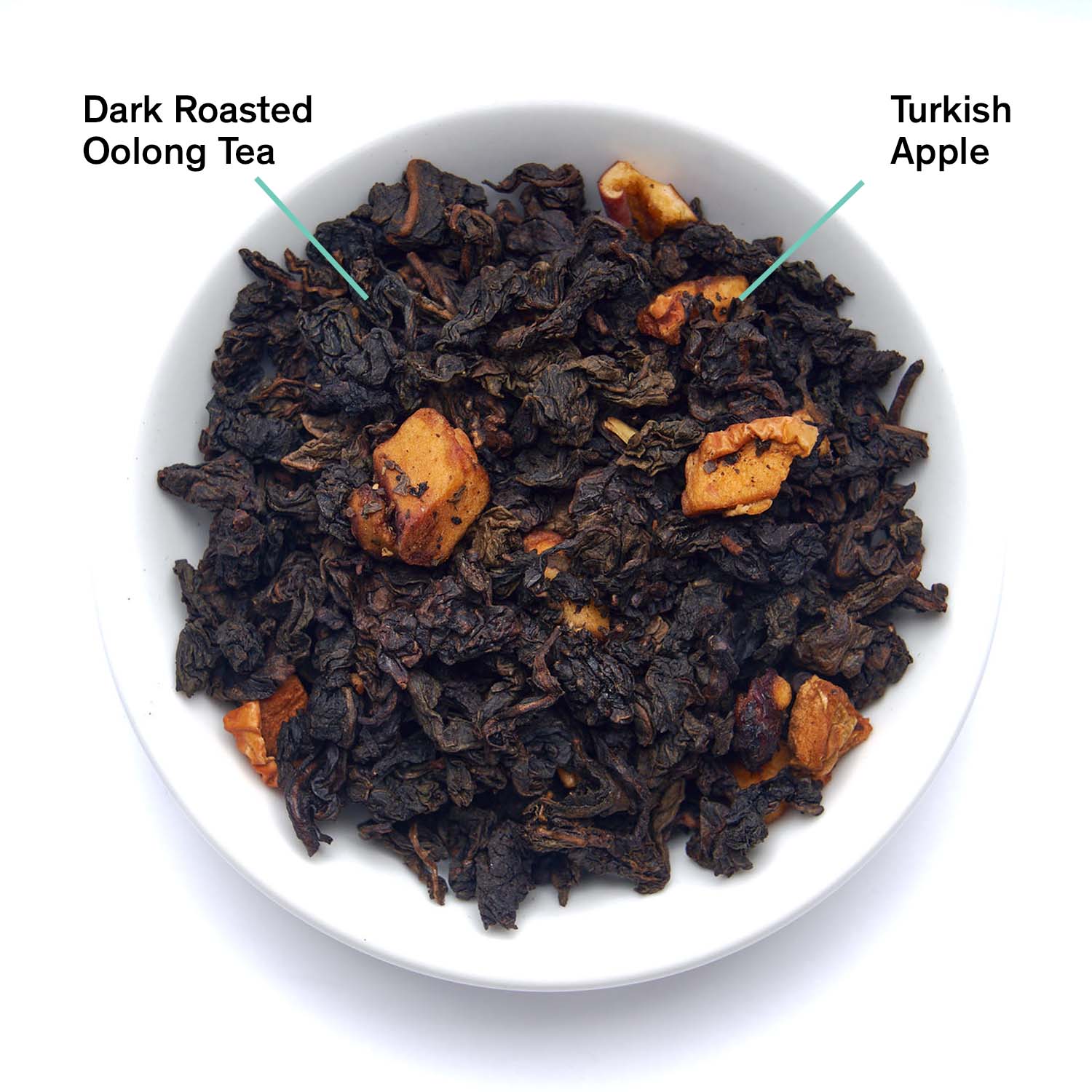 Dark roasted oolong tea with Turkish apple pieces in a white bowl.