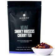August tea package with a bowl of smoky hibiscus cherry tea leaves on a white background
