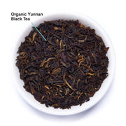 Organic Yunnan Black Tea leaves in a white bowl on a white background