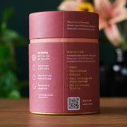 Tea canister with brewing instructions and product details on a wooden surface.
