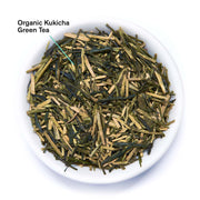 Organic Kukicha Green Tea leaves in a white bowl on a white background