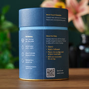 Blue tea canister with text and QR code on a wooden surface