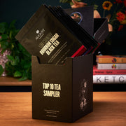 Black tea sampler box with tea bags on a wooden surface