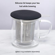 Glass mug with silicone lid for tea brewing on a white background