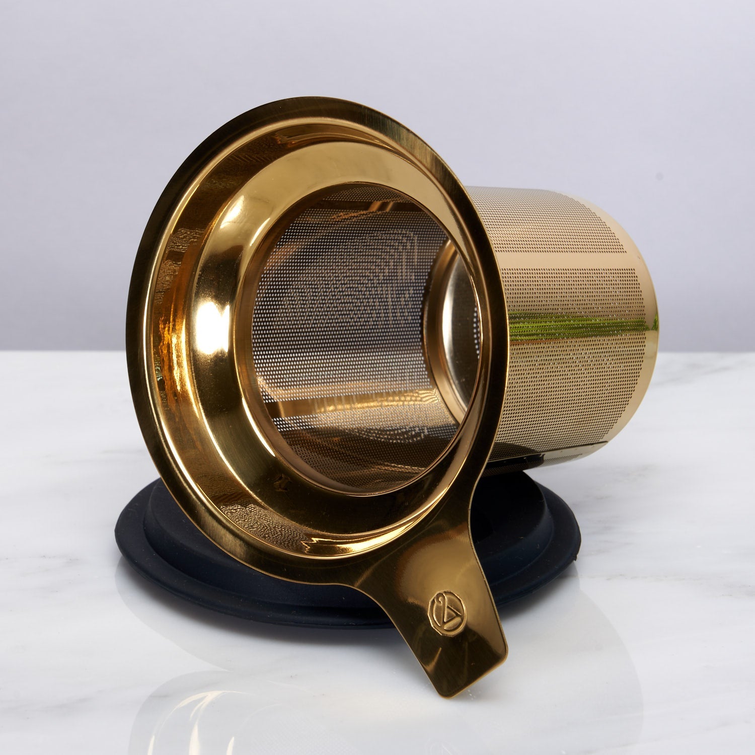 Gold tea infuser on a white background