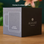 Black and gray gift box with 'August Uncommon' branding on a wooden surface.