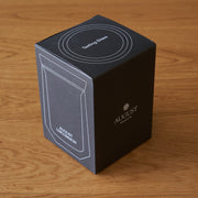 Black box with white text and branding on a wooden surface