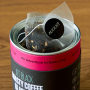 Tea bag in a canister with 'August' branding on a wooden surface