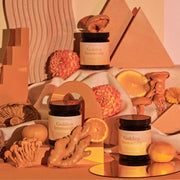 Jars labeled 'Golden Immunity' surrounded by natural elements like oranges and flowers on a warm-toned background.