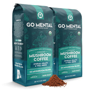 Two packages of Go Mental Organic Mushroom Coffee on a white background with coffee grounds in front.