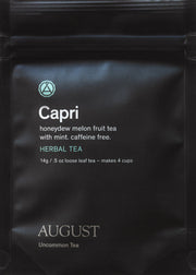 Black tea package with 'Capri' and 'August Uncommon Tea' branding.
