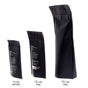 Three black coffee bags of different sizes on a white background