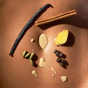 Spices and vanilla bean on a brown surface