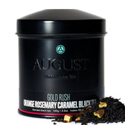 Black tea canister with 'August Uncommon Tea' branding and tea leaves on a white background