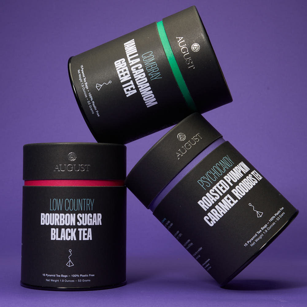 Black tea tins with white text on a purple background
